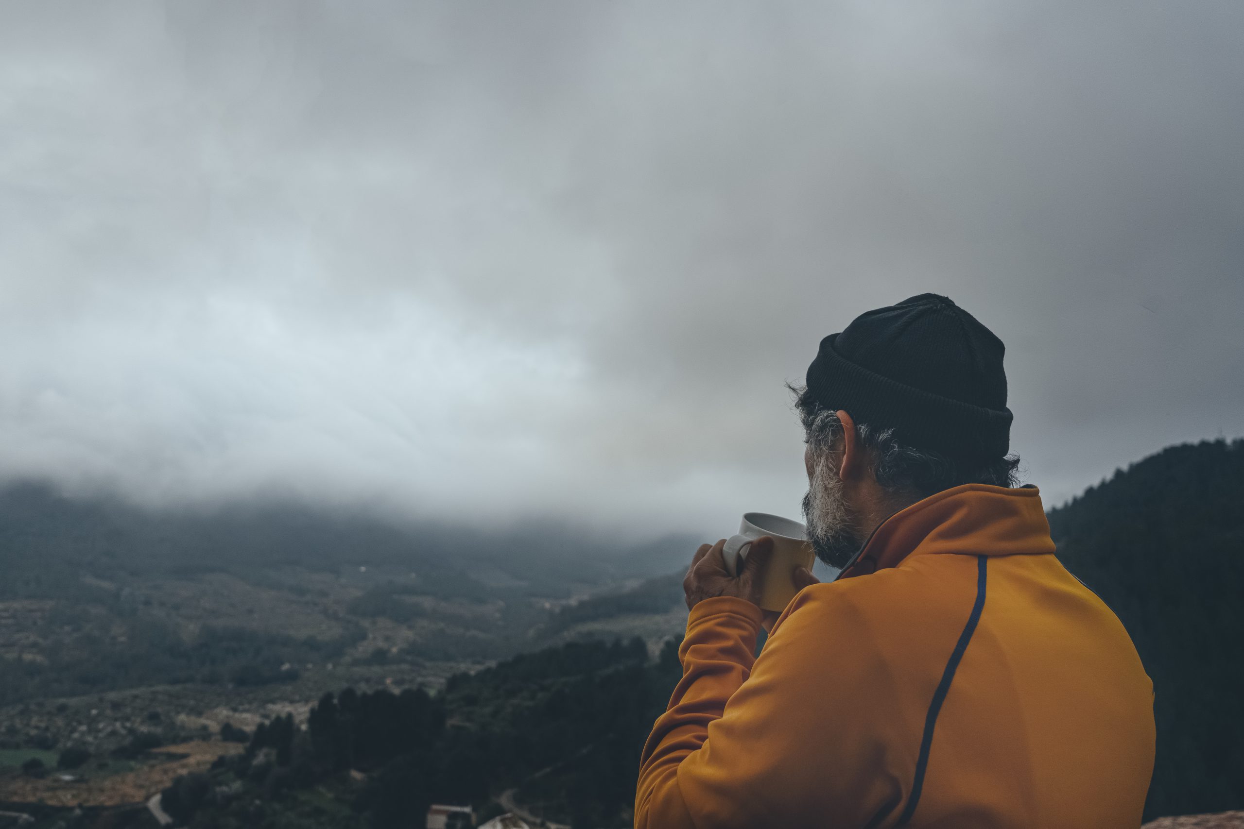 Senior Male Enjoying View While Drinking Coffee Gloomy Sky Scaled